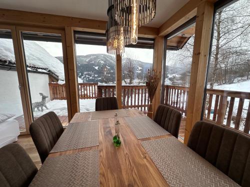 comedor con mesa y sillas frente a las ventanas en DAS MANFRED, en Sankt Michael im Lungau