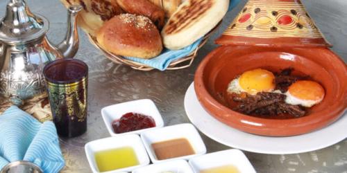a table with a bowl of food and some bread at شقق للكراء اليومي بالرشيدية Errachidia in Er Rachidia