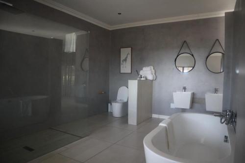 a bathroom with a tub and a shower and a toilet at The Meander Estate in Balmoral