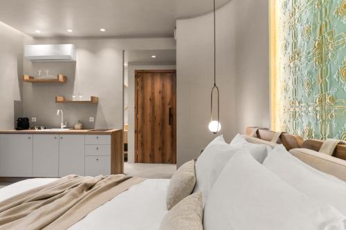 a bedroom with a white bed and a kitchen at ACRON 12 penthouse Acropolis suites in Athens