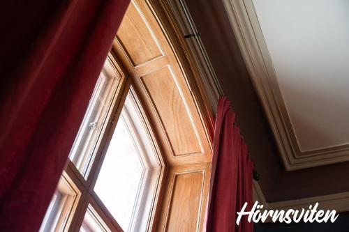 a window in a room with a red curtain at Merlo Slott in Timrå
