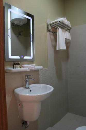 a bathroom with a white sink and a mirror at Lina Dreamland Resort in Billah