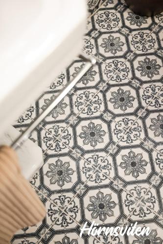 a white and gray tiled floor in a bathroom at Merlo Slott in Timrå
