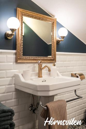 a bathroom with a white sink and a mirror at Merlo Slott in Timrå