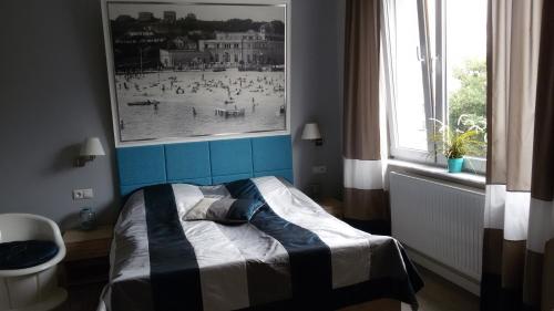 a bedroom with a bed and a picture of a beach at Pokoje i Apartamenty Retro Gdynia in Gdynia