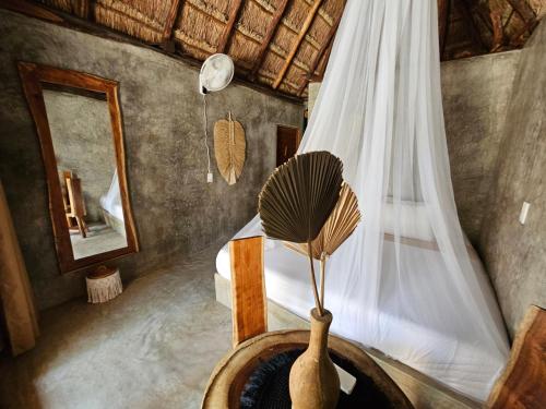 uma sala com um quarto com uma cama e um espelho em Cabañas Playa Condesa em Tulum