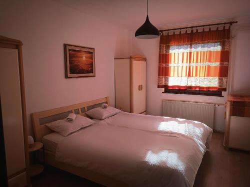 een slaapkamer met een bed met 2 kussens en een raam bij Hiša Žičanka in Loče pri Poljčanah