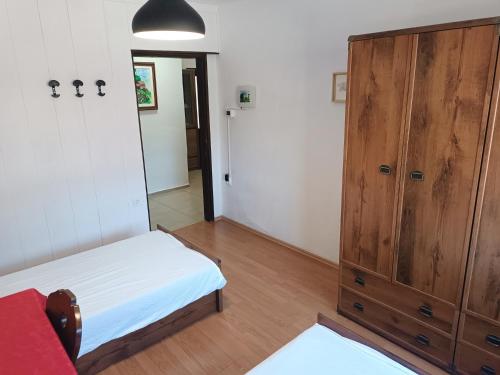 a bedroom with a bed and a wooden cabinet at Hiša Žičanka in Loče pri Poljčanah