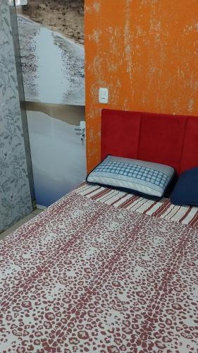 a bed in a room with a red head board at Morada Sol e Lua Container Guarda do Embaú com Ar condicionado in Guarda do Embaú