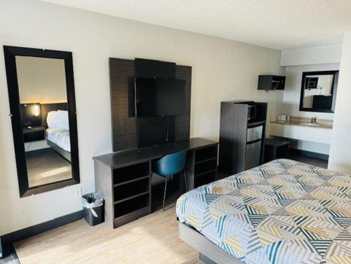 a hotel room with a bed and a desk and a mirror at Motel 6-Cedar Rapids, IA in Cedar Rapids