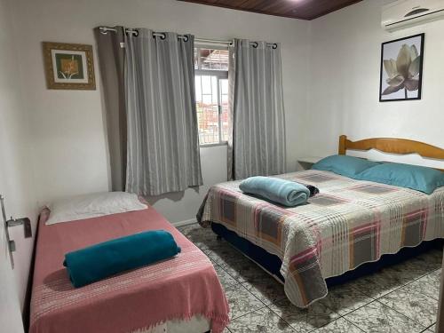 - une chambre avec 2 lits et une fenêtre dans l'établissement Amplo apart. com sacada com ultra wifi, à Florianópolis