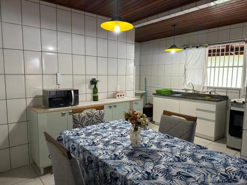 una cocina con una mesa con un jarrón de flores. en Amplo apart. com sacada com ultra wifi, en Florianópolis