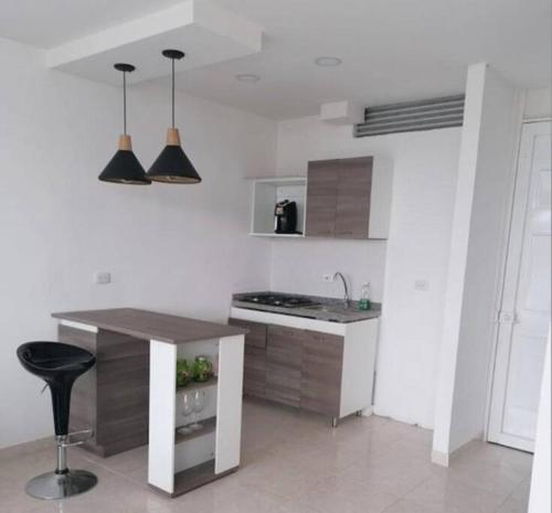 cocina blanca con mesa y encimera en Apartamento Completo. 2 Habitaciones, aire acondicionado, conjunto cerrado en Girardot