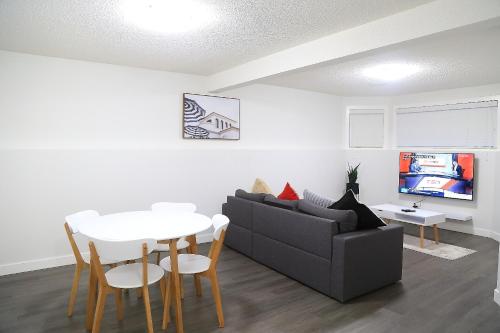 a living room with a couch and a table at Cozy 3 beds Suite Near Calgary Airport Sleeps 6 in Calgary