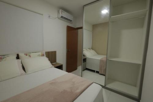 a hotel room with a bed and a glass wall at Apartamento Luxuoso à 2km da Litorânea in São Luís