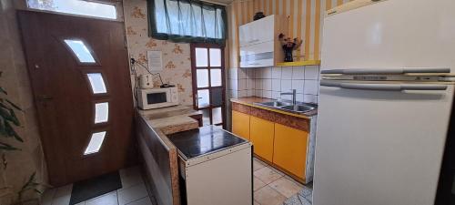 eine kleine Küche mit einem Kühlschrank und einer Mikrowelle in der Unterkunft Sárkány Lak in Diósd