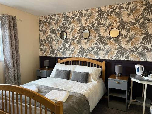 a bedroom with a bed and a wall with a flower pattern at The Island View in Berwick-Upon-Tweed