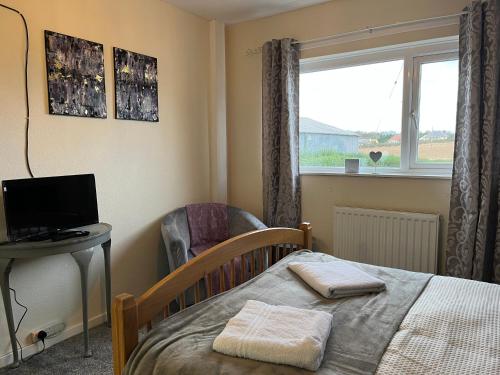 a bedroom with a bed and a desk and a window at The Island View - A1 in Berwick-Upon-Tweed