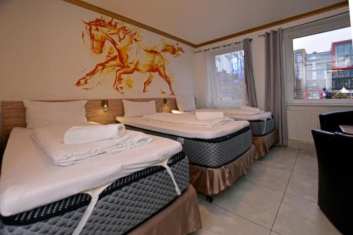a room with three beds with a horse on the wall at Ambiente by Next Inn in Hamburg