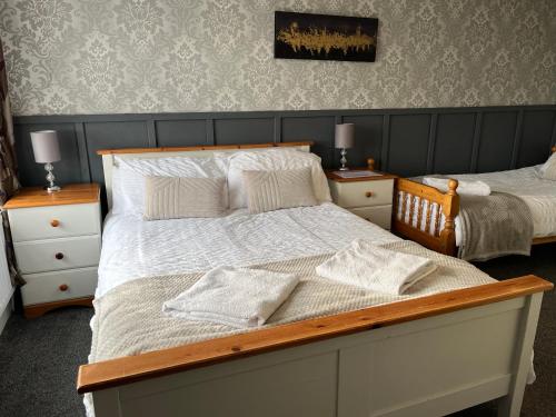 a bedroom with two beds with white sheets and pillows at The Island View - A1 in Berwick-Upon-Tweed