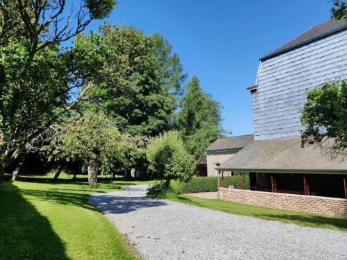 a house with a gravel driveway next to a building at Clos des Rogations in Saint-Hubert