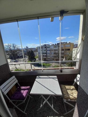 balcón con 2 sillas y ventana en Apartman Pava en Bosanska Gradiška