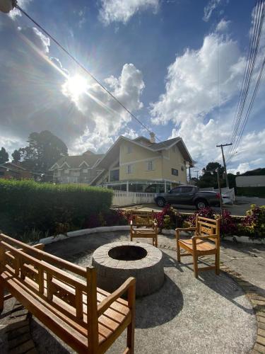 a group of benches sitting around a fire pit at Pousada Jordão in Campos do Jordão