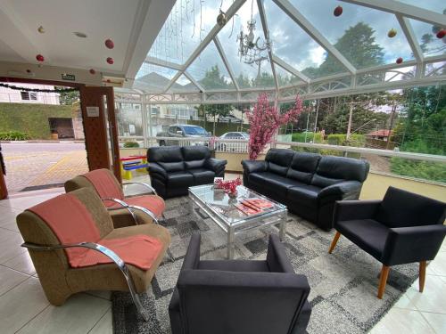 a living room with couches and chairs and a table at Pousada Jordão in Campos do Jordão