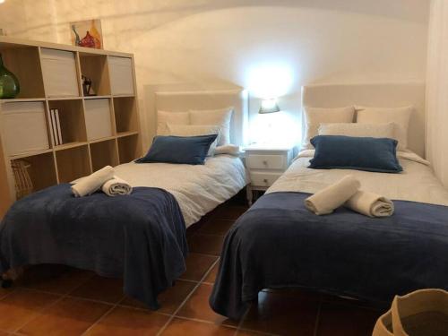 a bedroom with two beds with blue and white pillows at Casa Rodríguez - La Herradura in La Herradura