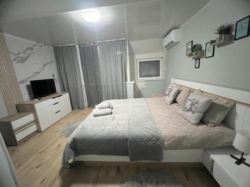 een kleine slaapkamer met een bed en een televisie bij Център Варна апартамент in Varna