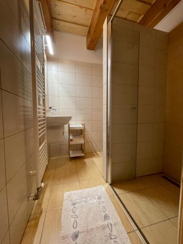 a bathroom with a sink and a shower and a rug at Villa Milan in Vysoke Tatry - Tatranska Lomnica.