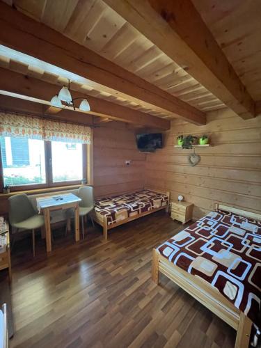 a room with two beds and a table in a room at Villa Milan in Vysoke Tatry - Tatranska Lomnica.