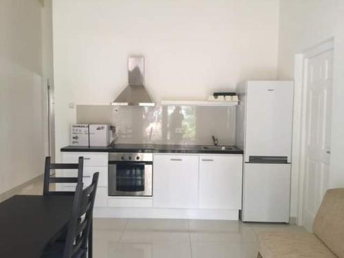 uma cozinha com electrodomésticos brancos e uma mesa preta em Caribbean Court E1 em Kralendijk