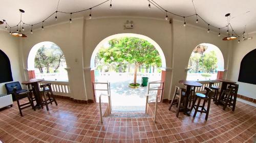 an empty room with tables and chairs and a tree at El Boulevard de Huacachina in Ica