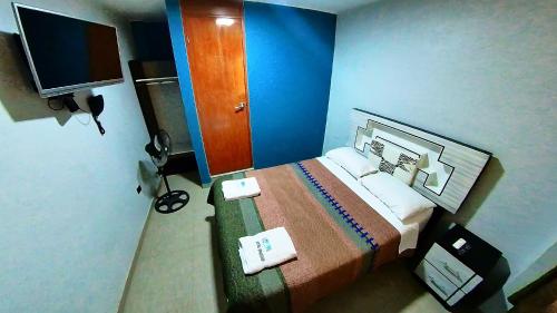 a hotel room with a bed and a television at El Boulevard de Huacachina in Ica