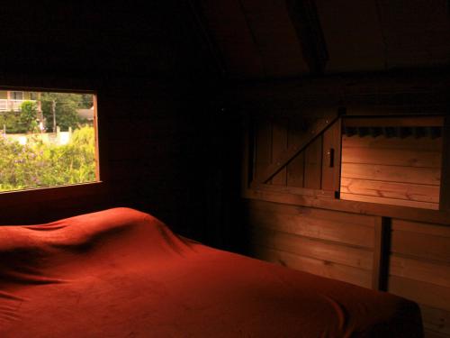 a bedroom with a bed and a window at Valhalla Glamping House in Bombinhas