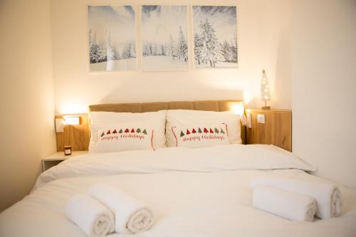 a bedroom with a bed with white sheets and pillows at GreenMont Jahorina in Jahorina