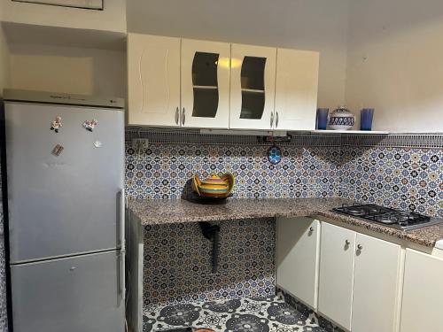 a kitchen with white cabinets and a tile floor at Dar Nana in Sousse