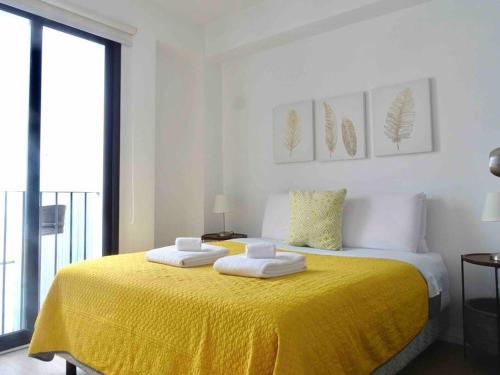 a bedroom with a yellow bed with two towels on it at Cómodo e íntimo departamento en Centro Historico in Mexico City