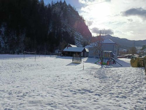 un parque infantil en la nieve con una montaña en Cazare La Piatra Buhei, en Câmpulung Moldovenesc
