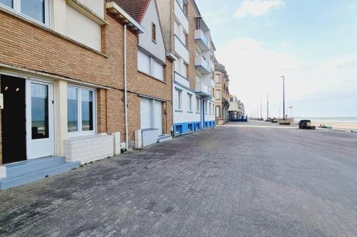 an empty street in front of a brick building at Maison des Marées - Digue de mer in Bray-Dunes