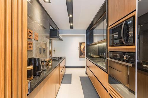 a kitchen with wooden cabinets and a counter top at Apartamento Mundo in Guarujá