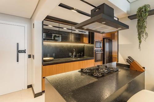 a kitchen with a black counter top and a stove at Apartamento Mundo in Guarujá
