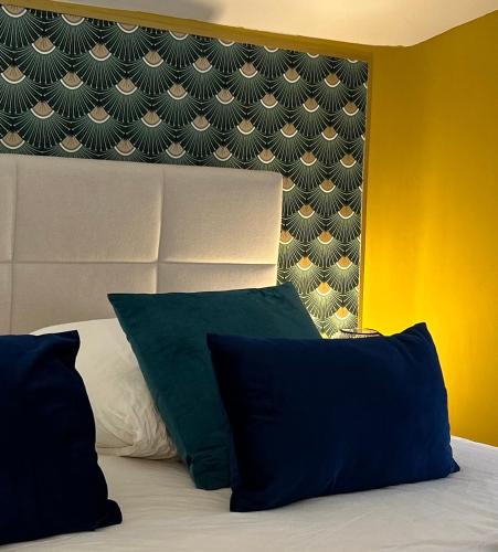 a bedroom with a bed with two pillows and a headboard at Appart' Studio cooconing - Champs Elysées - NETFLIX in Maisons-Laffitte