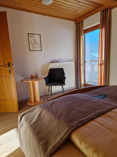 a bedroom with a bed and a chair and a window at Kastnerhof in Jenig