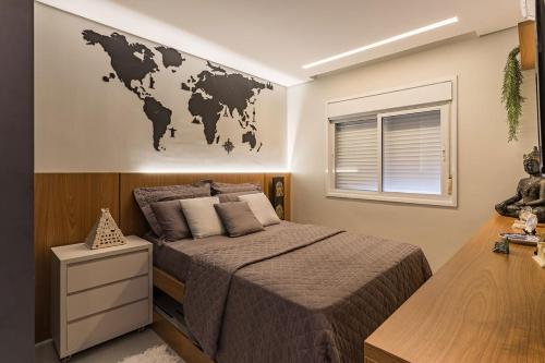 a bedroom with a large bed with a map on the wall at Apartamento Mundo in Guarujá
