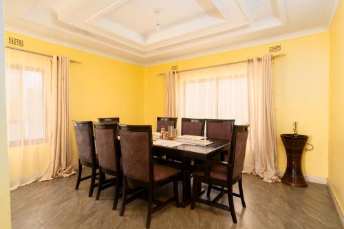 uma sala de jantar com uma mesa preta e cadeiras em Misty BnB em Lilongwe