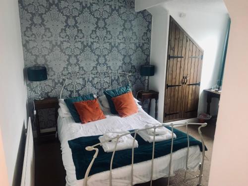 a bedroom with a bed with colorful pillows on it at Ye Olde Nags Head in Castleton