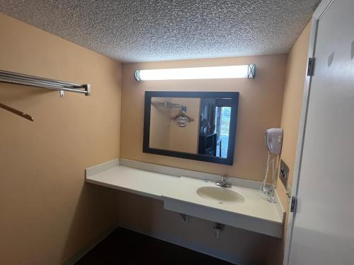 a bathroom with a sink and a mirror at Rodeway Inn Davenport-Champions Gate in Davenport