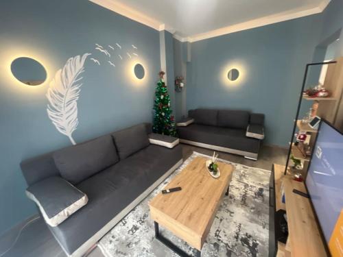 a living room with a black couch and a christmas tree at Casa Kleisoura in Klisoúra